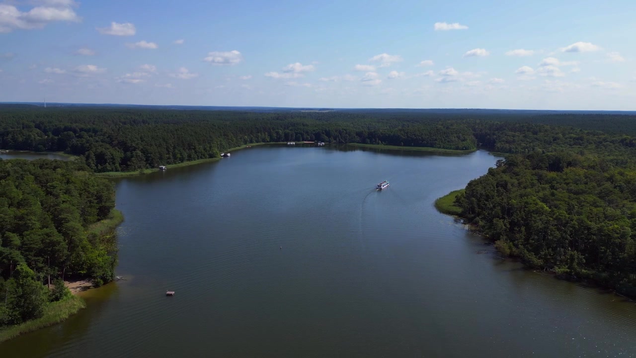 Traghetto passeggeri su un lago calmo circondato da una foresta verde in una soleggiata giornata estiva in Germania. Fantastica vista aerea panoramica con drone.