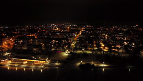 drone shot ascending in front of the night lit vaasa city, in osterbotten, finland