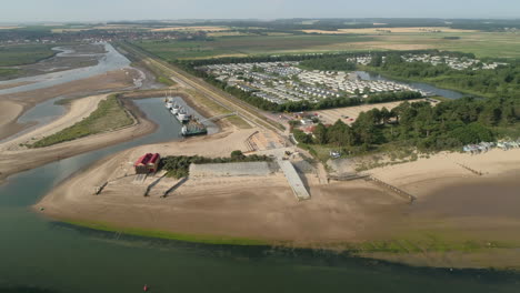 toma de drones de pozos junto al mar casa de botes salvavidas y parque de casas de vacaciones de caravanas estáticas con playa de arena en el norte de norfolk, costa este del reino unido