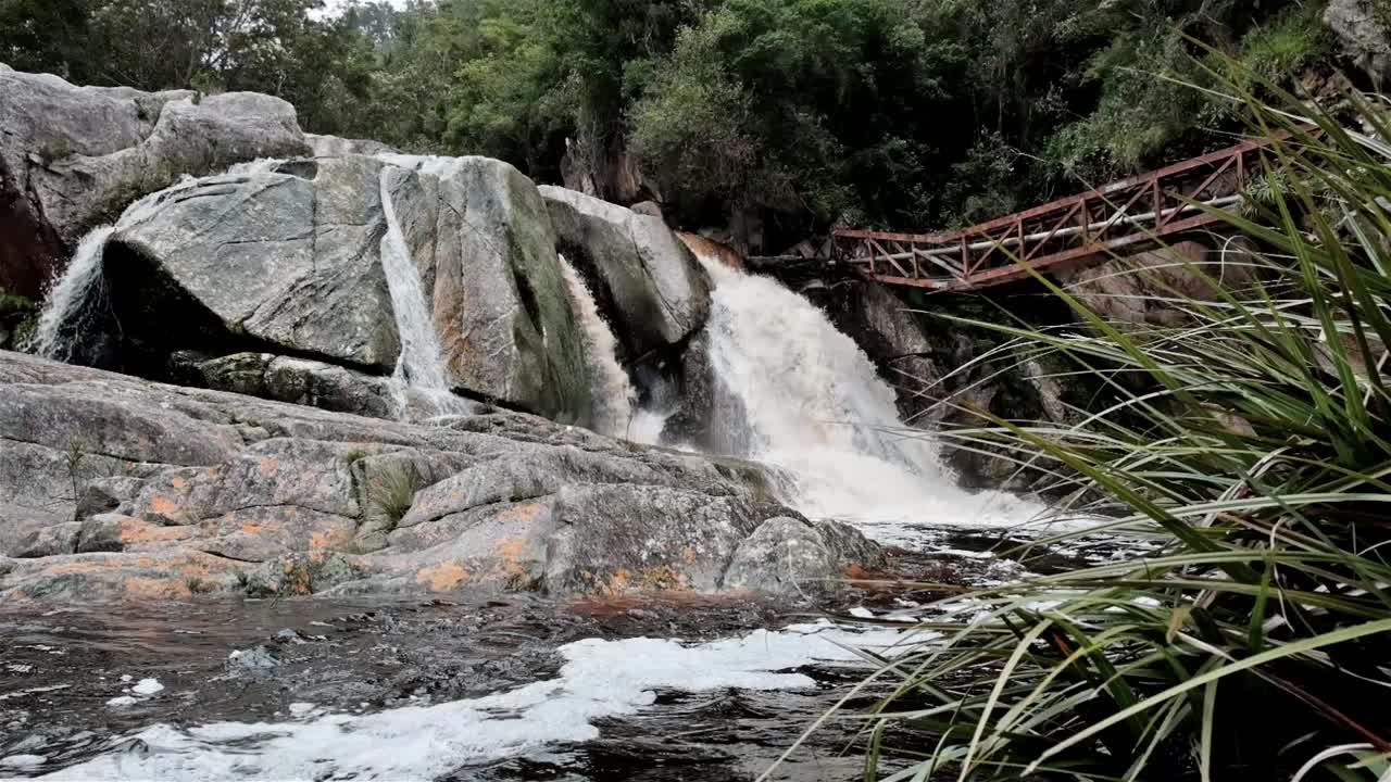 el río fluye sobre grandes rocas durante una inundación creando una cascada