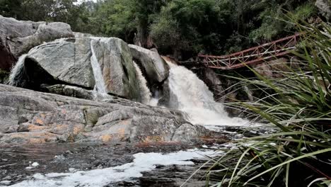 River-flows-over-large-boulders-during-a-flood-creating-a-waterfall