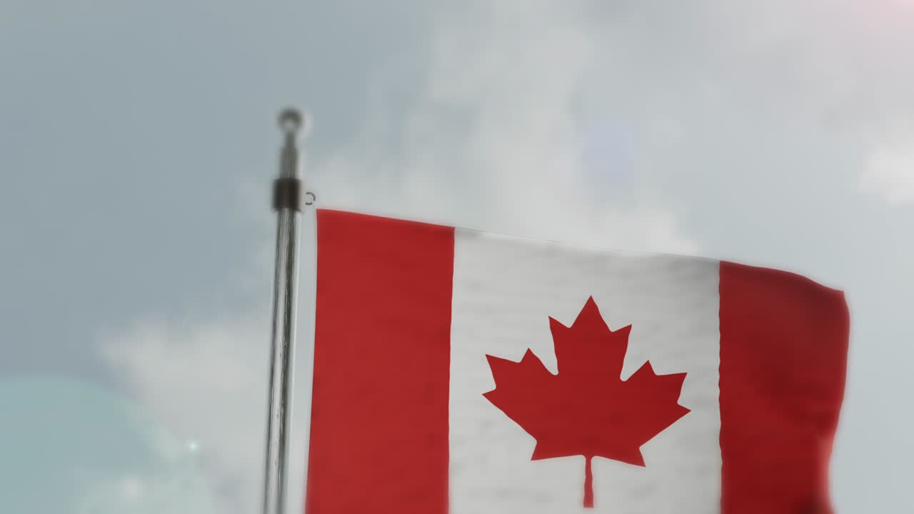 Bandiera canadese che sventola su un pennone contro un cielo nuvoloso