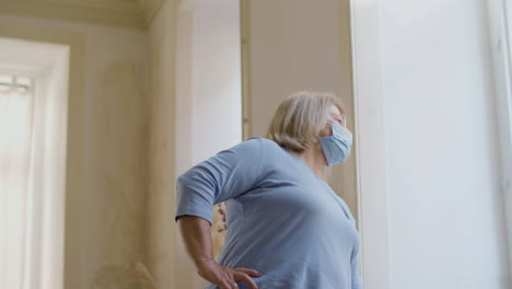 medium shot of old woman in medical mask looking at wristwatch