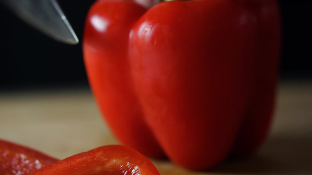 빨간 피망의 측면을 통해 날카로운 요리사 칼 슬라이스 및 절단