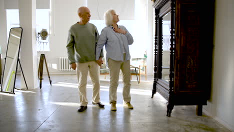 senior couple looking at an antique piece of furniture in a studio