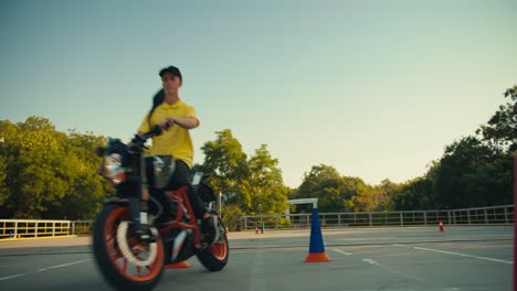 dos motociclistas van a lados diferentes en el campo de entrenamiento en una escuela de motocicletas