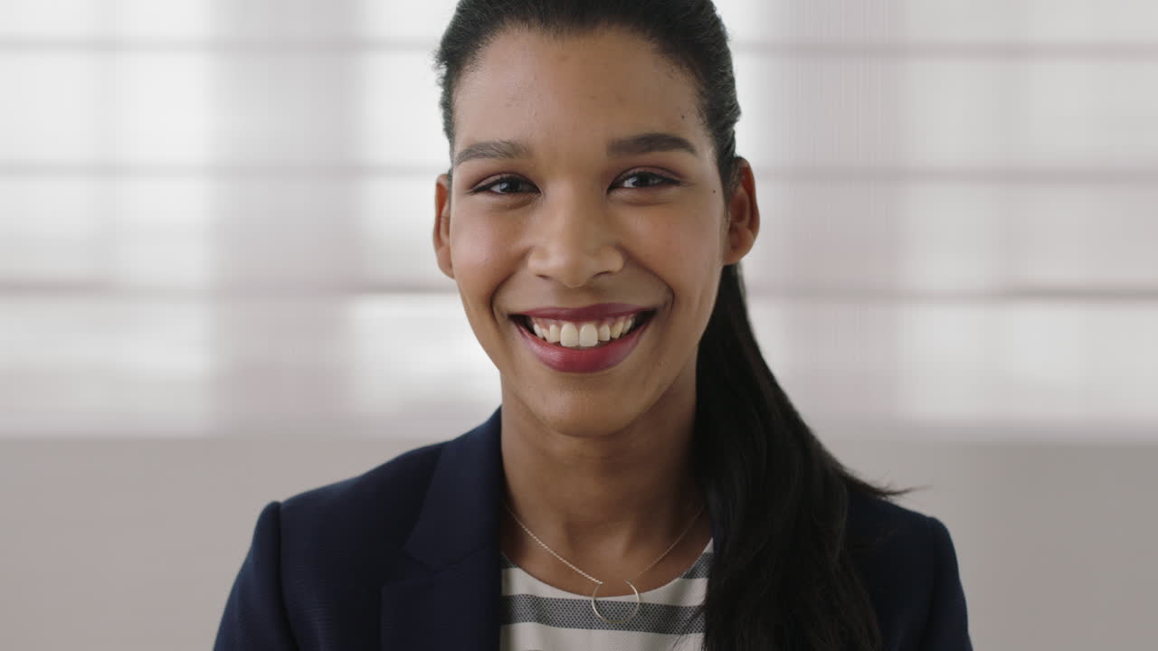 ritratto di giovane donna d'affari di razza mista indipendente sorridente felice guardando la telecamera ambiziosa dirigente femminile da vicino