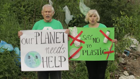 voluntarios mayores con carteles de protesta nuestro planeta necesita ayuda, digamos no al plástico. contaminación de la naturaleza