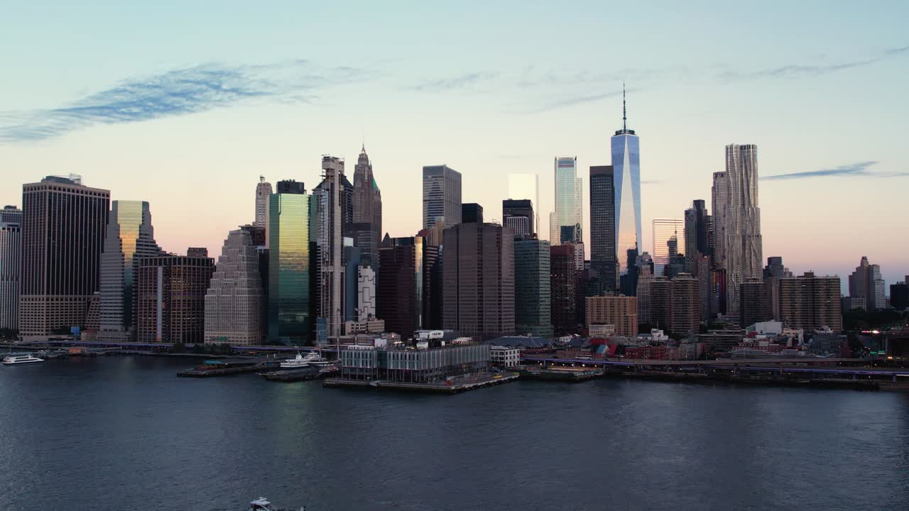 Veduta aerea di un traghetto davanti allo skyline di Manhattan, all'alba a New York, USA - ripresa ascendente con drone.