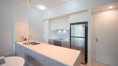 modern minimal apartment kitchen with electric cook top and large stainless steele oven interior