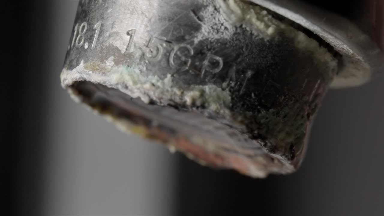 Water Flowing Strongly from Limescale Covered Faucet Macro