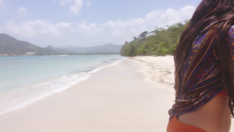 sonriente feliz despreocupada dama latina coqueteando mirando la cámara en la playa tropical, playa teco maimon, república dominicana, tiro de mano