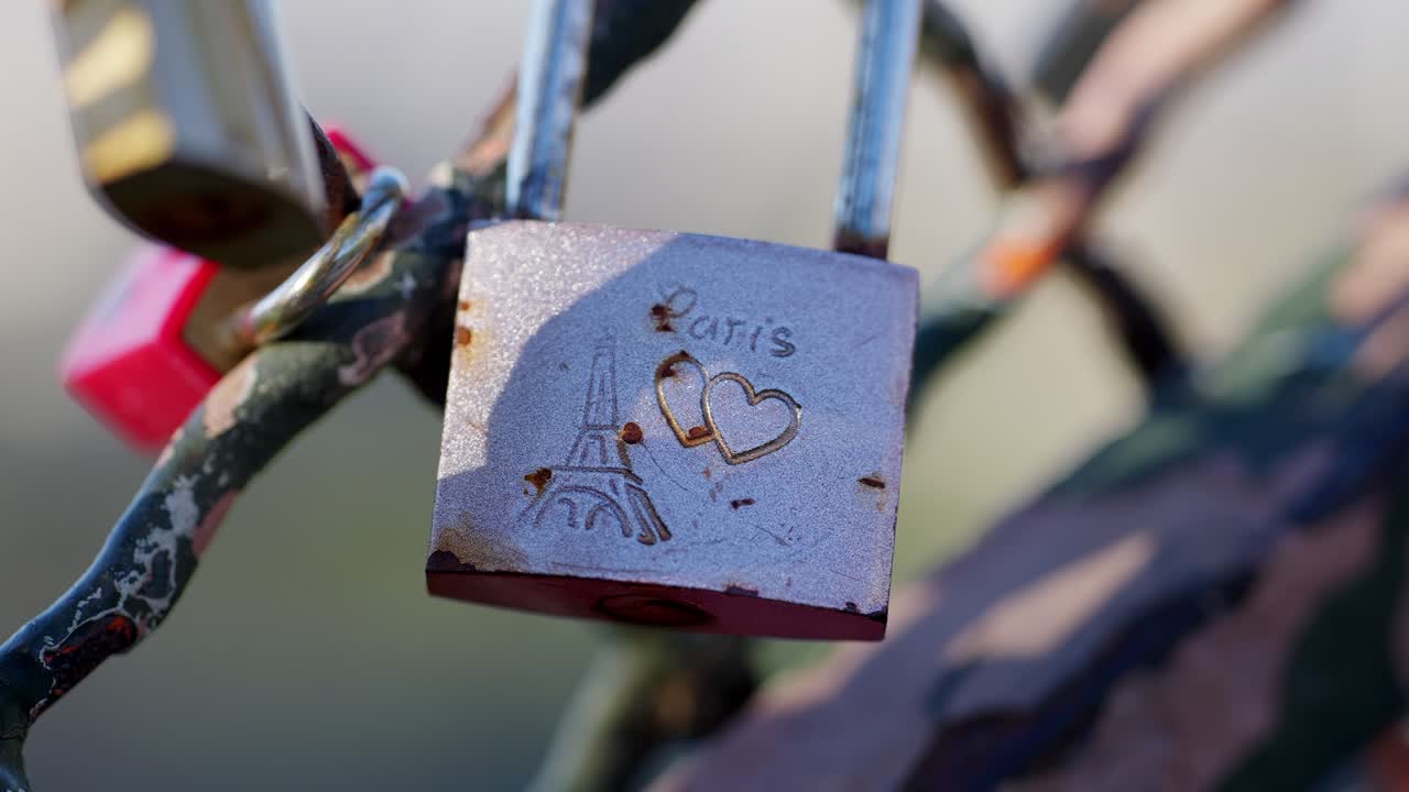 Close up view of a Pink and rusty Love lock in a fence in Montmartre Paris during summer days.
