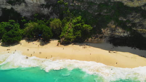 top down view of a crowd of tourists at a tropical sand beach