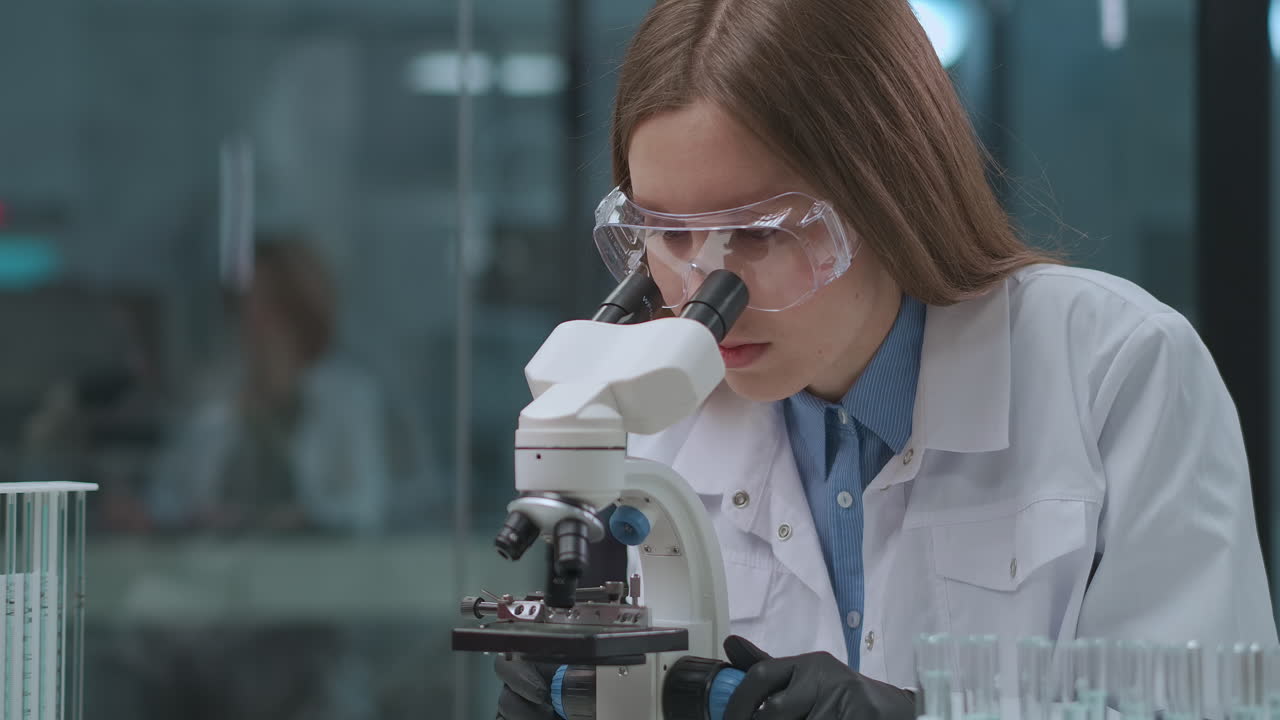 forensic expert is testing evidence in laboratory viewing samples in microscope female technician is researching analysis portrait of woman in lab