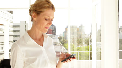 mujer de negocios enviando mensajes de texto por teléfono