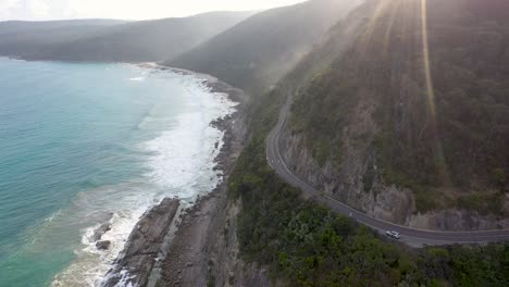 Gran-Vista-Aérea-De-Ocean-Road-Con-Luz-Solar-Y-Rayos-De-Sol,-Victoria,-Australia