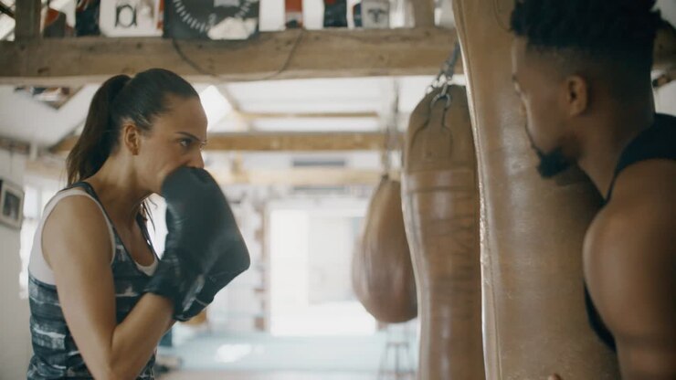 Donna e uomo che si allenano in una palestra di boxe
