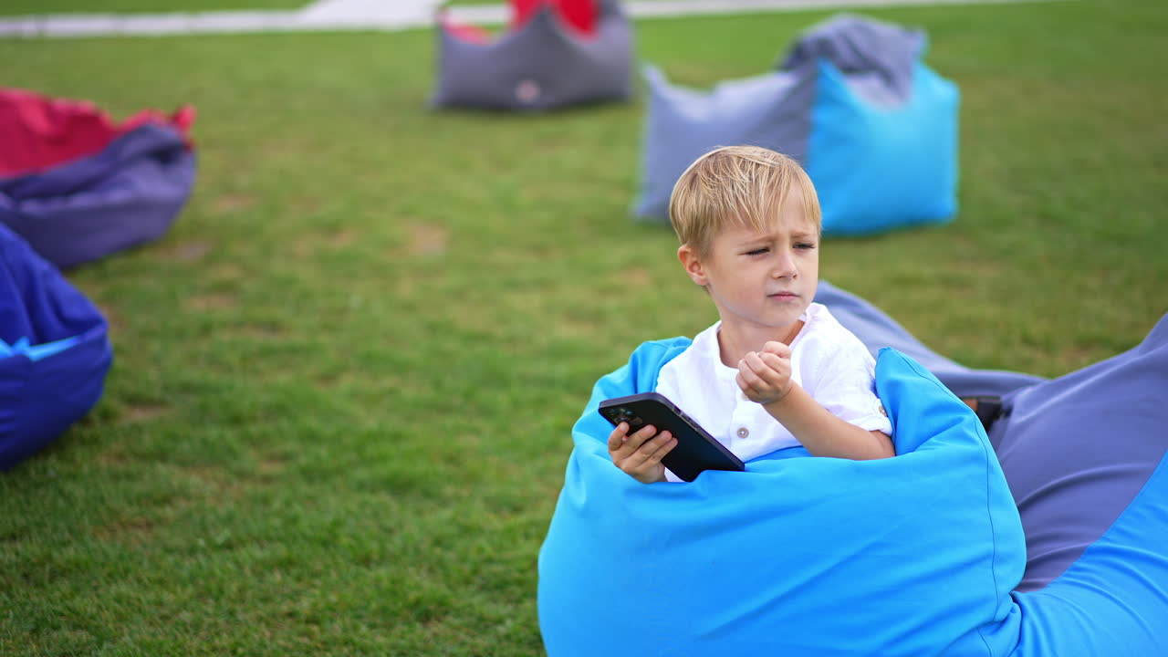 Boy using a mobile phone in a park