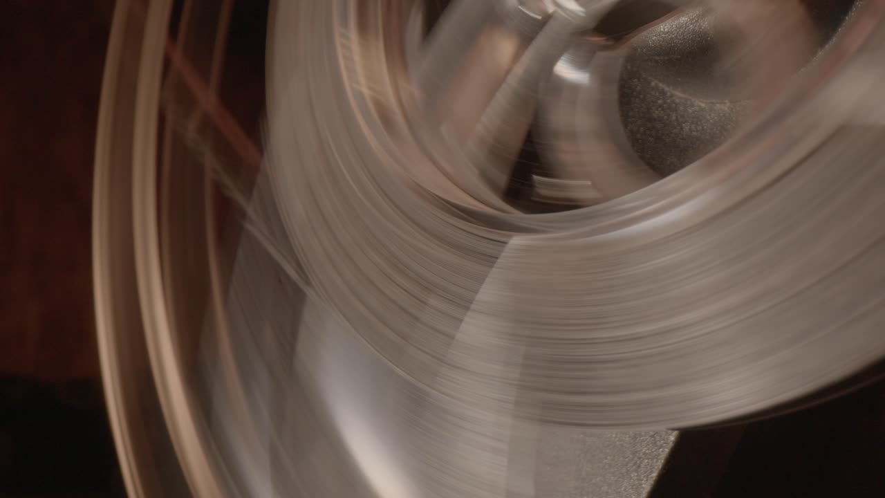 회전하는 스풀에 움직이는 필름 스트립의 클로즈업, 느려지고 가속화