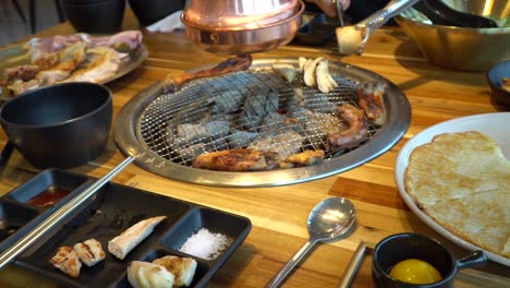 Cutting-mushroom-On-The-Griller---Egg-Yolk-And-Pizza-On-The-Table-In-A-Korean-chicken-Restaurant-In-Chuncheon-City,-South-Korea---close-up,-slider-shot