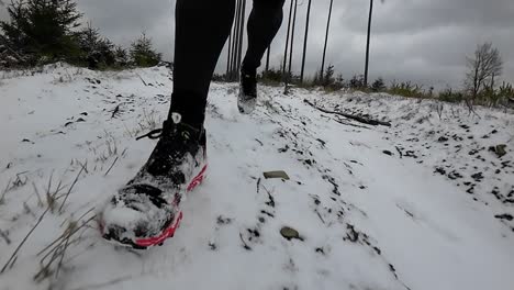 close up front view slow motion of a trail runner on steep wintery forest downhill trail