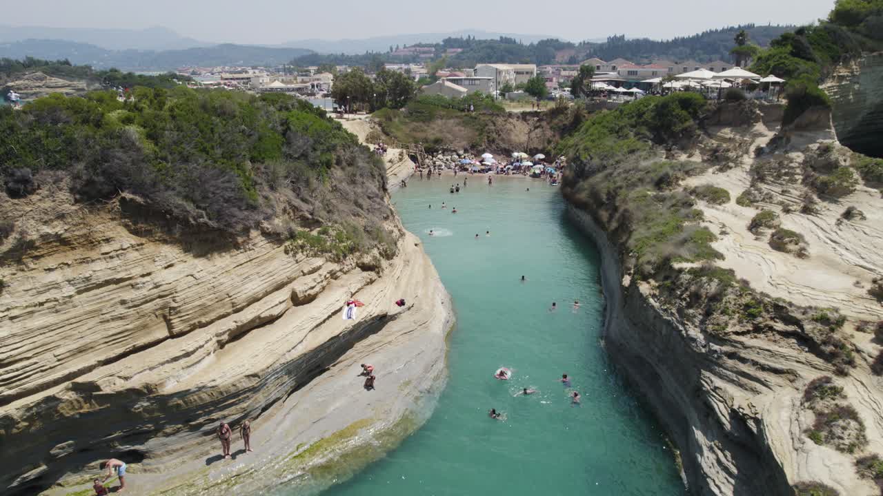 Aerial establishing shot of Canal D'Amour with people jumping off of the cliffs