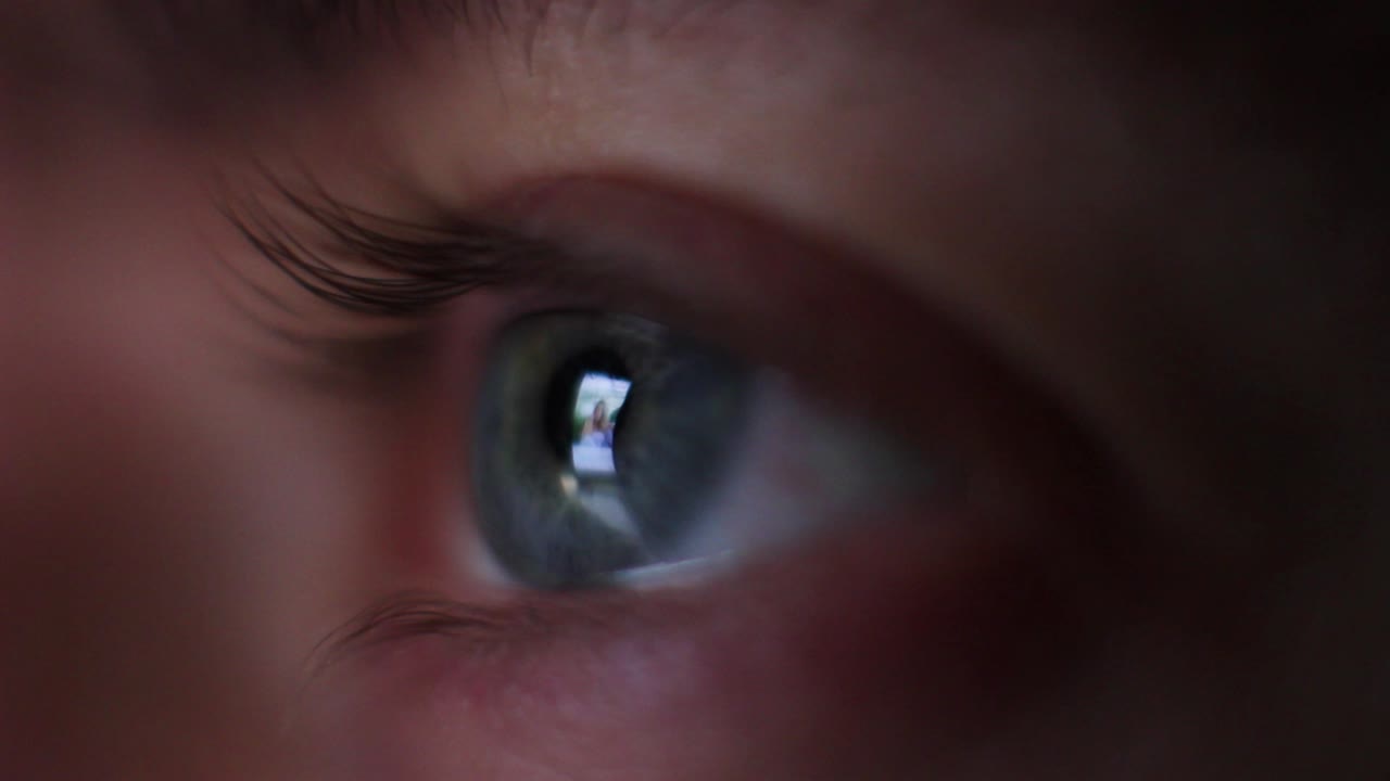 A macro shot of an eye looking into social media. Man is scrolling through the pages