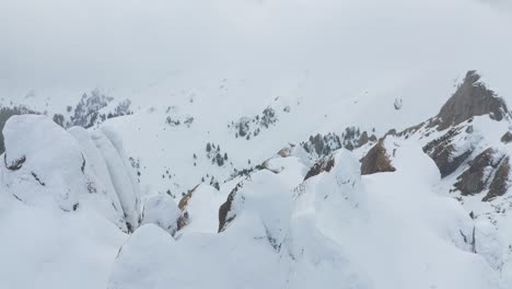 Snow-capped-Ciucas-Mountains-partially-hidden-by-cloud-cover,-tranquil-and-serene,-aerial-view