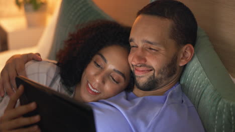 Couple,-smile-and-relax-in-bedroom-with-tablet