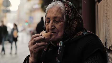 an elderly woman savoring a traditional snack is captured on a bustling street. people pass by, showcasing a vibrant city atmosphere in the afternoon light.