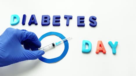 lettering diabetes day. blue circle, drugs and syringe.