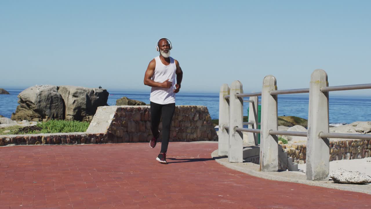 Senior african american man exercising running on road by the sea