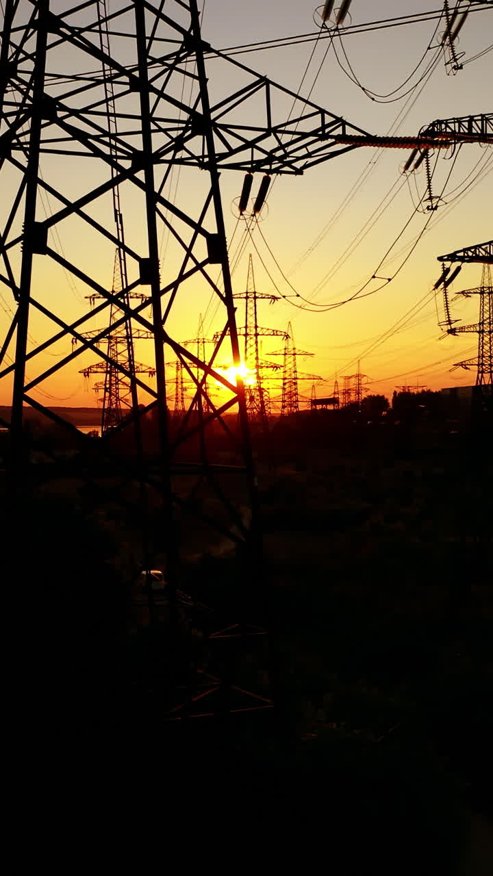 Power lines on colorful sunset. Electric post with wires with sunset background