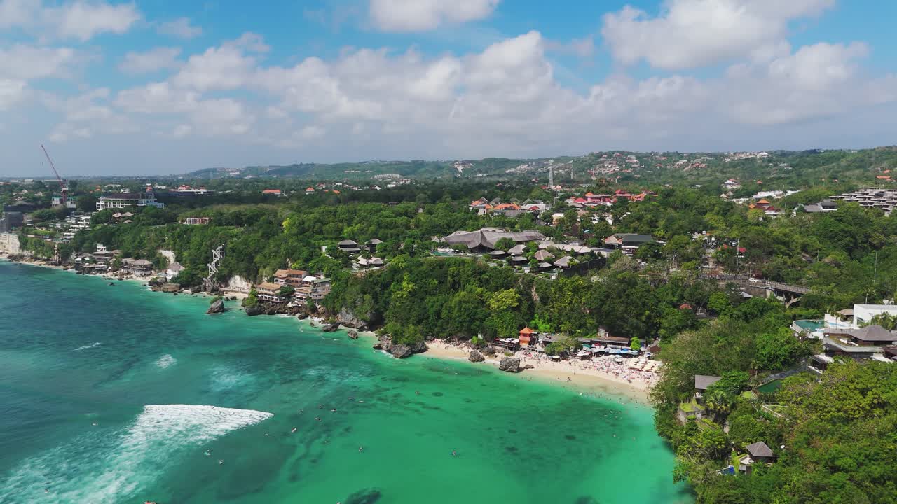 Clear water of Padang Padang beach in uluwatu, Bali. Sunny summer day with neighborhood in background. Aerial wide shot