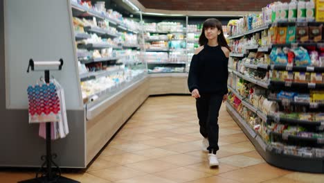 independent teenager in the supermarket, passing by food sections