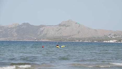 Kiteboarding-Und-Wingfoil-Surfer-In-Cear-Blue-Water-Auf-Mallorca-Balearen,-Umgeben-Von-Bergen