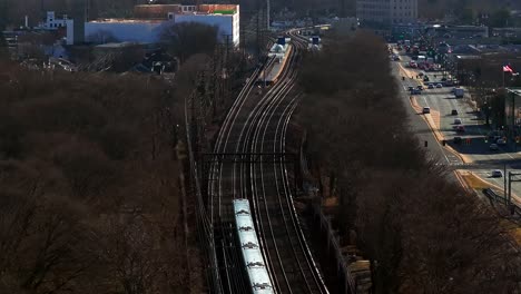 an aerial view of a long island rail road train, heading to the next station on a sunny day