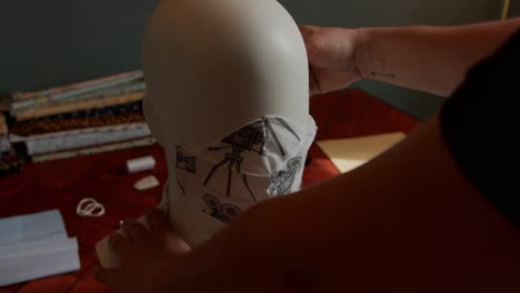head mannequin being fitted with a mask in slow motion from shoulder pov