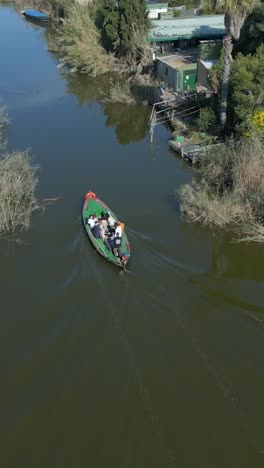 people riding a boat on a river surrounded by greenery