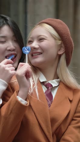 two women enjoying lollipops