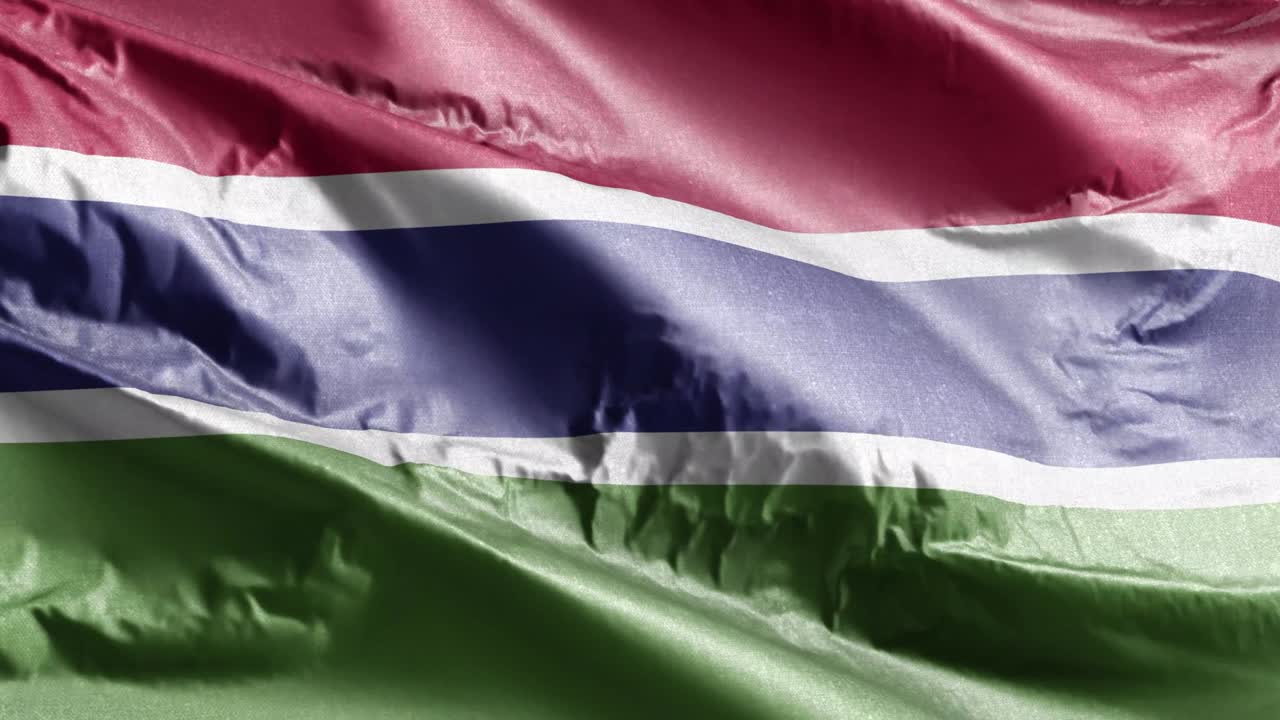 Gambia textile flag waving on the wind loop. Gambian banner swaying on the breeze. Fabric textile tissue. Full filling background. 10 seconds loop.