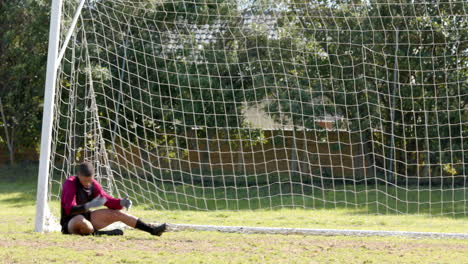 goalkeeper diving to save soccer ball during match on sunny day