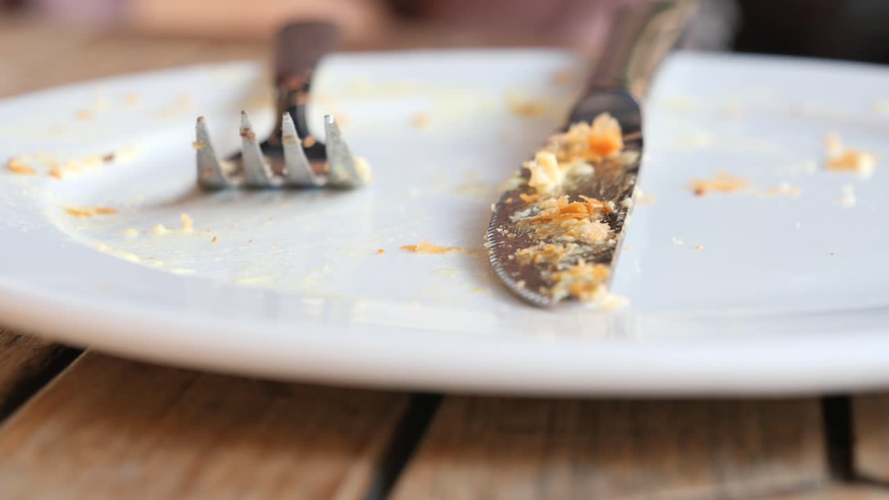 Empty Plate with Utensils and Food Debris