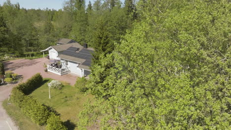 drone circling a house with sunlight collectors on the roof, sunny. spring day