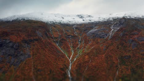 the powerful glacier covers the rocky plateau, framed by the vibrant colors of autumn and trickling streams