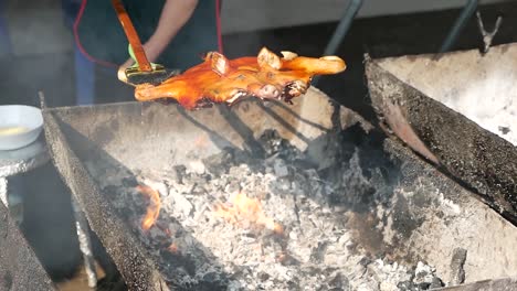 la cocción de un cerdo asado de cuerpo entero cocinado con parrilla de carbón