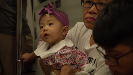 cute baby girl riding metro train in the city of singapore. close-up shot