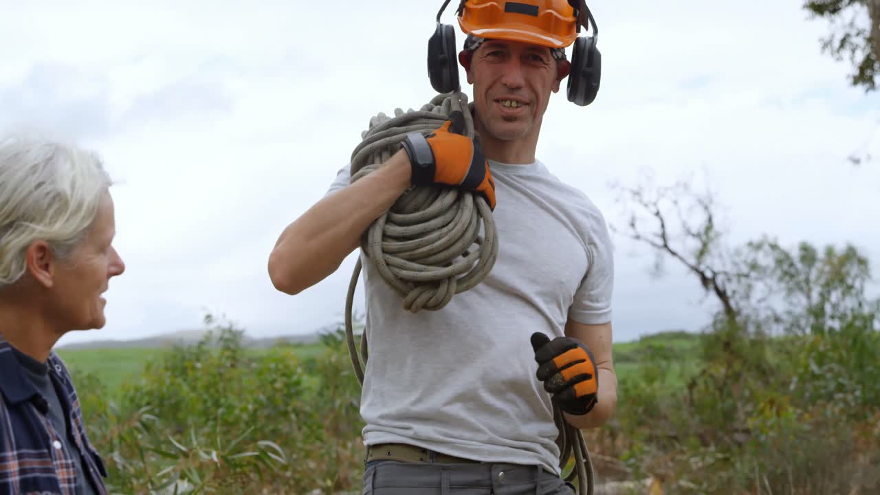 leñador llevando una cuerda en el bosque 4k