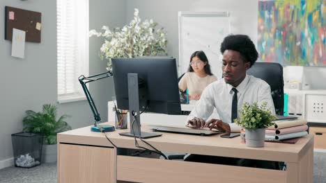 an experienced handsome company employee dressed in a shirt and tie prepares documents on the computer, drafts an article or a speech, sends messages to clients, taps fingers on the keyboard